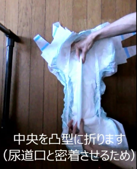 おむつを広げて、中央を凸型に折る